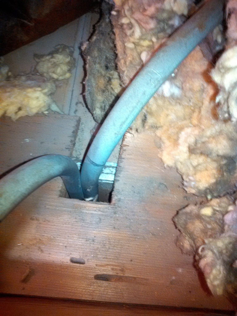 Picture shows gap around electical conduit that allows lighter-than air water vapor to rise up into attic